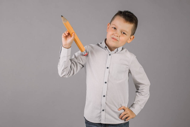 chłopiec trzyma wielki ołówek, pojęcie szkoły, edukacja - Zdjęcie, obraz