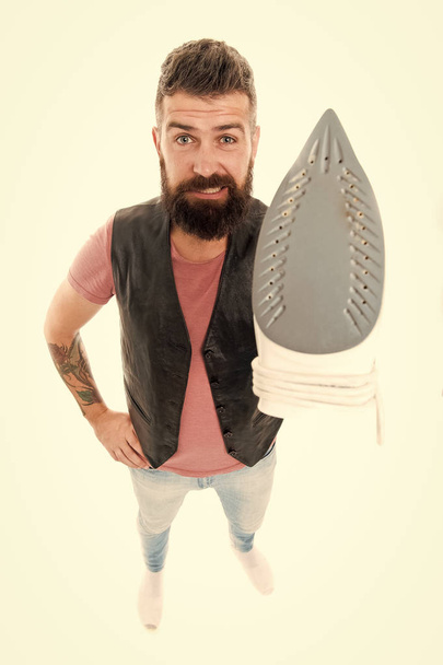 Heat up iron. Man bearded hipster hold electric ironing tool. How to iron clothes correctly. Be careful. Guy with iron on white background isolated. Tailor and dry cleaning service. Household duty - Φωτογραφία, εικόνα