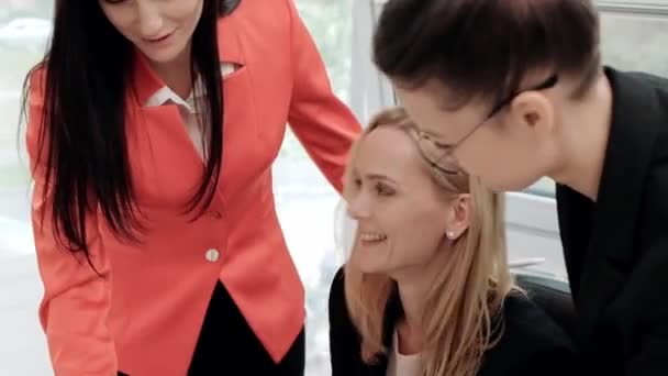 Drie jonge aantrekkelijke vrouwen in business suits zitten aan een bureau en bespreken workflows. Hoofd en ondergeschivelde. Werk team van professionals en collega's. - Video