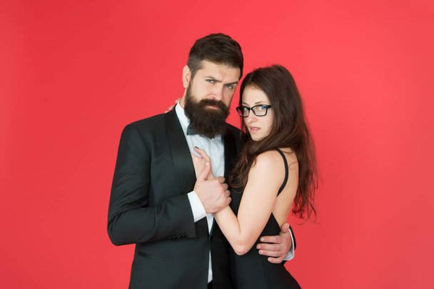 Feel rhythm of heart. Lets dance tonight. Elegant couple in love tender hug dancing red background. Happy together. Man in tuxedo and woman black dress dancing at party. Passionate couple dancing - Фото, изображение
