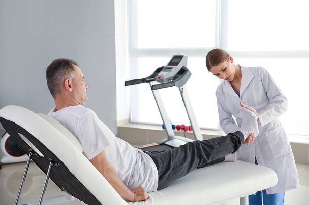 Physiotherapeutin arbeitet mit erwachsenen Patienten im Reha-Zentrum - Foto, Bild