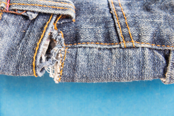 jeans apilados sobre fondo de madera.jeans azules sobre fondo de madera marrón.Jeans deshilachados.Detalle de bonitos jeans azules con cinturón de cuero en estilo vintage.
 - Foto, imagen