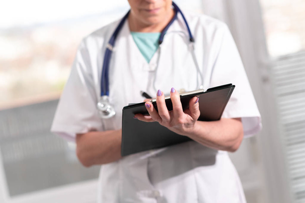 Женщина-врач делает заметки на планшете
 - Фото, изображение
