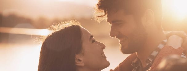 ロマンチックな愛するカップルは、日没にキス - 写真・画像