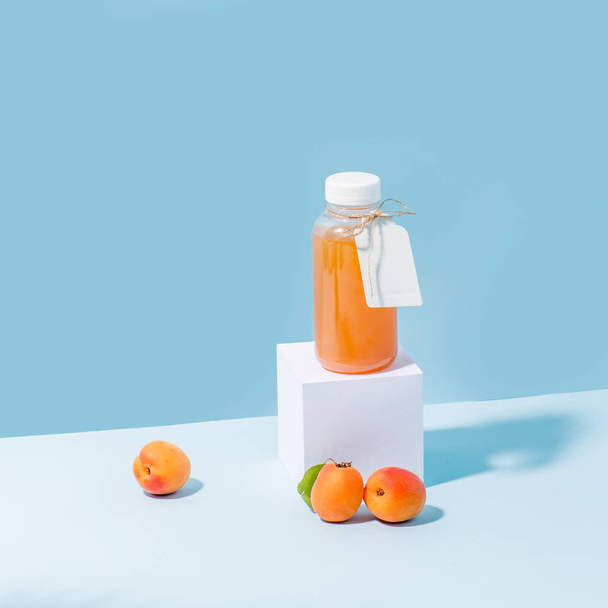 Composition of peach juice on pedestal and fresh apricots - Foto, imagen