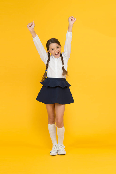 Back to school. Student little kid adores school. Emotional schoolgirl. Celebrate knowledge day. September time to study. Girl adorable pupil on yellow background. School uniform and fashion - Photo, image