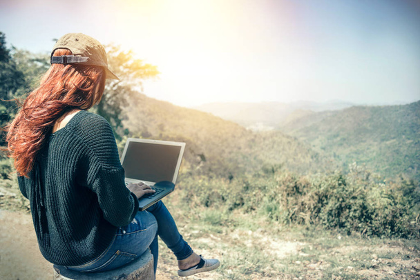 Woman working in a natural park using a notebook. nature, outdoor, holiday, relax, travel, summer, education, read, laptop, note book, computer. - Photo, Image