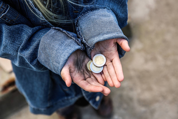 Homeless little girl with coins outdoors - Photo, Image
