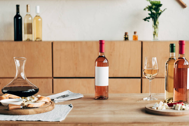 Flaschen Wein, Weinglas und Essen auf Holztisch - Foto, Bild