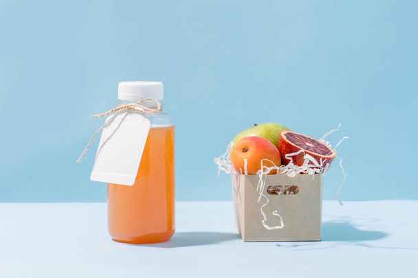 Peach juice and fresh fruits in compostable paper container full of saw shavings - Valokuva, kuva