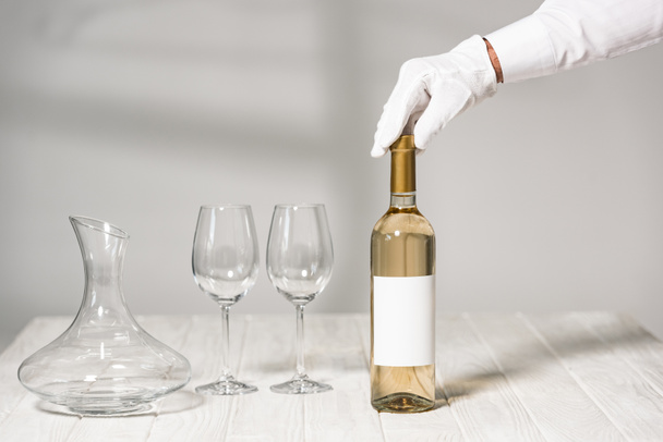 visão parcial do garçom segurando garrafa de vinho no restaurante
 - Foto, Imagem
