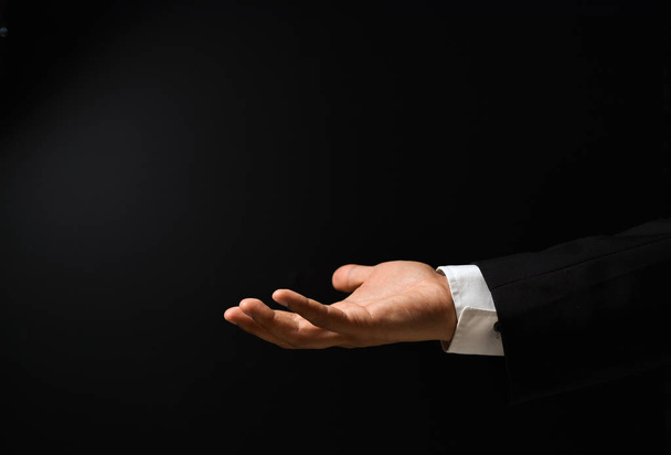 Businessman's hand on black background - Foto, afbeelding
