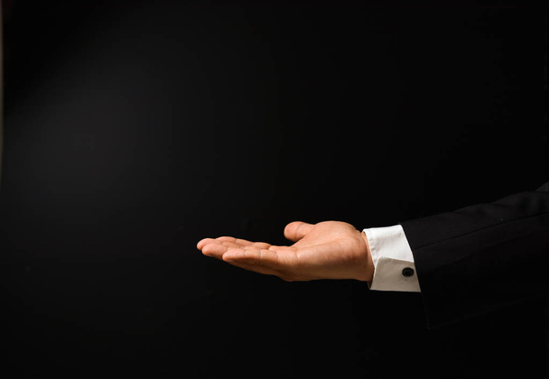 Businessman's hand on black background - 写真・画像
