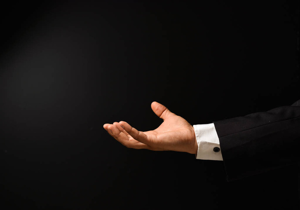 Businessman's hand on black background - Valokuva, kuva