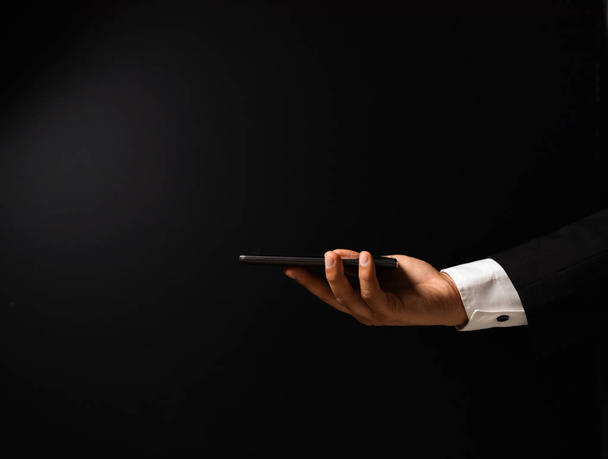 Businessman's hand on black background - Φωτογραφία, εικόνα