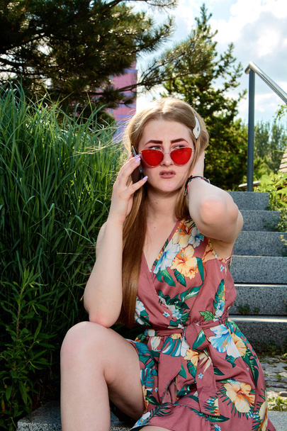 Young attractive woman. Red sunglasses, color dress, mobile phone, 5G, 4G, 3G, 2G, LTE network. - Fotoğraf, Görsel