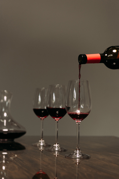 red wine pouring in wine glasses from bottle in restaurant - 写真・画像