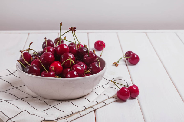Delicious ripe cherry in a white bowl - Фото, изображение