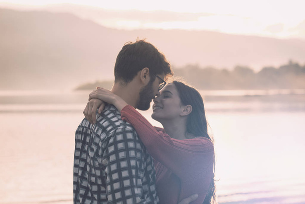 Joven pareja romántica besándose al atardecer
 - Foto, imagen