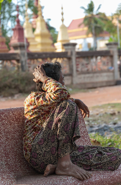 alte Kambodschanerin sitzt auf einer Bank - Foto, Bild