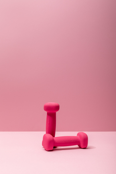 pink bright dumbbells on pink background with copy space - Fotografie, Obrázek