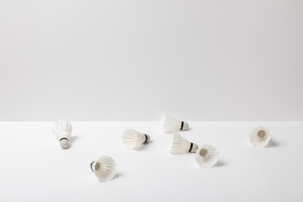 білі бадмінтонні човники розкидані на білому тлі
 - Фото, зображення