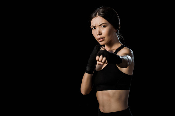 selective focus of girl boxing in gloves isolated on black  - 写真・画像