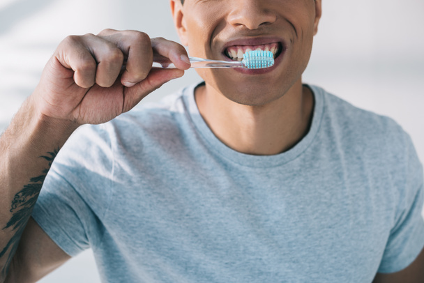 cropped view of man brushing teeth with toothbrush and toothpaste - Photo, Image