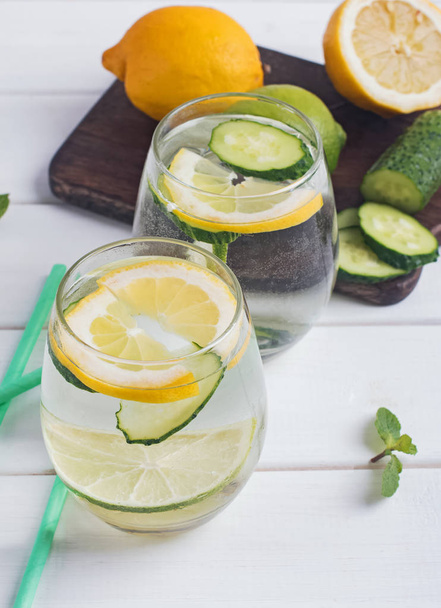 Water infused with mint, lemon and cucucmber on the white wooden table - Fotoğraf, Görsel
