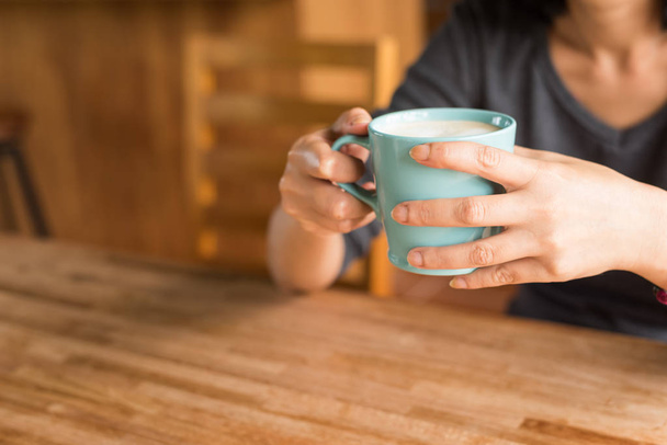 vrouw houdt een kopje koffie - Foto, afbeelding