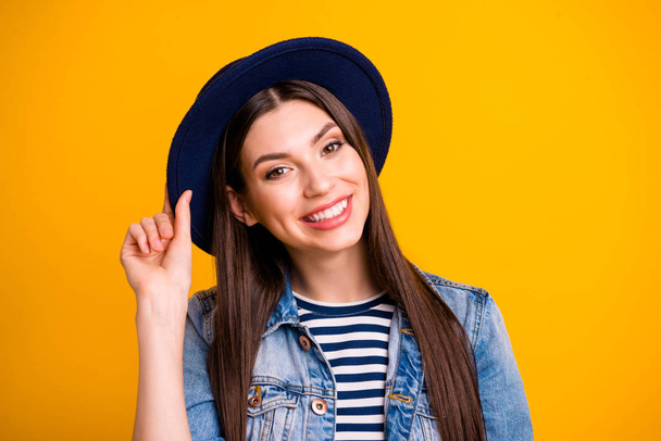 Close-up portrait of her she nice-looking sweet adorable attractive lovely lovable fascinating cheerful cheery straight-haired lady touching hat isolated over bright vivid shine yellow background - Foto, Bild