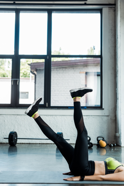 cropped view of young woman exercising on fitness mat near windows  - Fotoğraf, Görsel