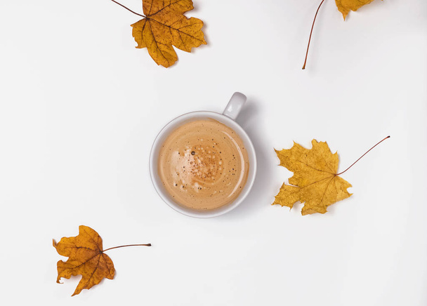Cup of coffee and yellow leaves on the white background - Photo, Image