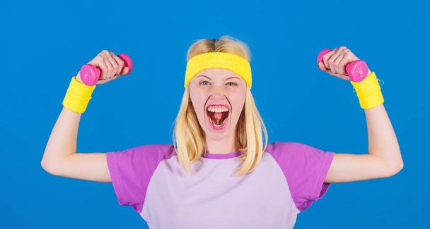 How to get toned physique. Beginner fitness exercises. Fitness upper body workout for women. Fitness concept. Girl exercising with dumbbell. Fitness instructor hold little dumbbell blue background - Fotoğraf, Görsel