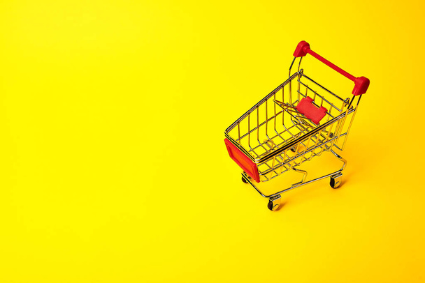 shopping trolley on yellow background - Photo, Image