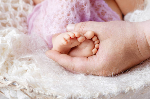  Piedi neonati in mani paterne. Padre che tiene le gambe della k
 - Foto, immagini