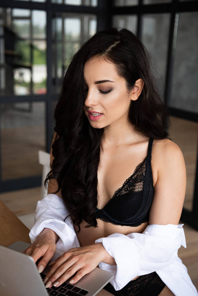 sexy girl in black underwear and white shirt using laptop with closed eyes - Foto, immagini