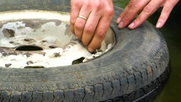 El hombre retuerce el pezón del casquillo rueda vieja del coche
 - Metraje, vídeo