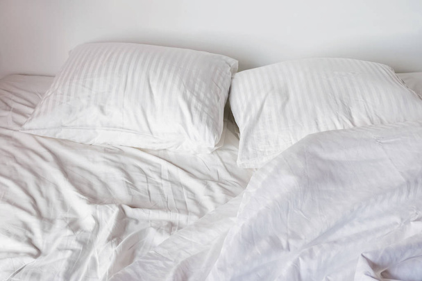 Messy bed with white pillows and sheets - Photo, Image