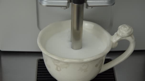 Příprava cappuccina na zpětu mléka nalévání kávové páry z kávovaru na porcelánový pohár - Záběry, video