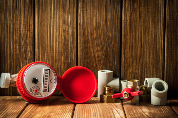 New water meter with fittings on a vintage wooden background. - 写真・画像