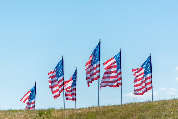 national american flags on green grass against blue sky with clouds  - Photo, image