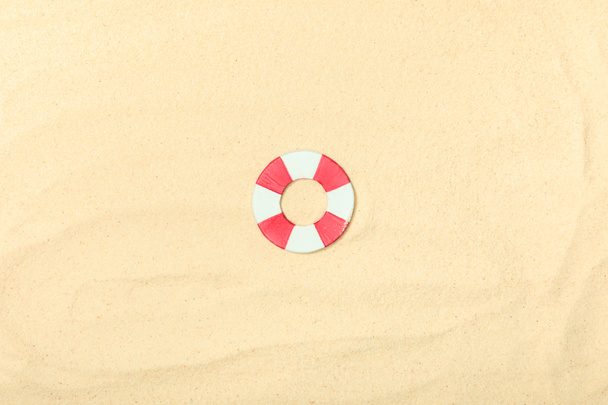 top view of paper beach with lifebuoy on textured sand  - Photo, Image