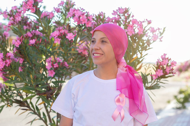 Mulher com cachecol rosa na cabeça
 - Foto, Imagem