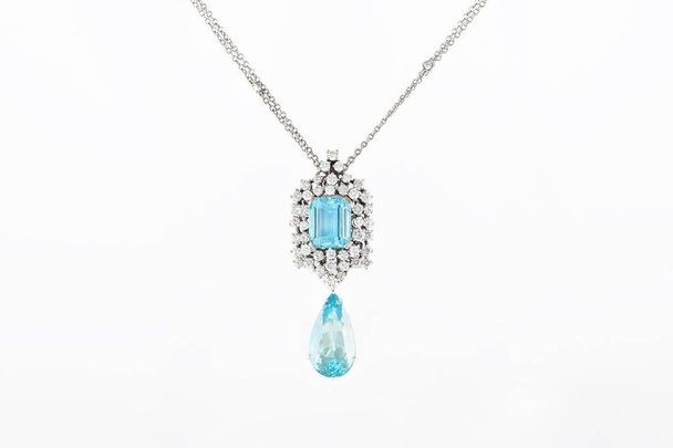 Luxury white golden pendant with blue gemstone and diamonds on stand. - Photo, Image
