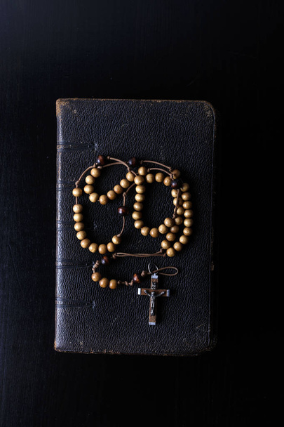 Rosary beads and prayer book on dark background. - Photo, Image
