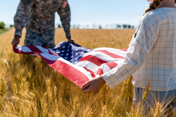selective focus of kid and military man holding american flag  - Valokuva, kuva
