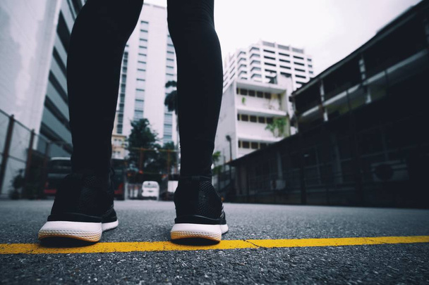 Kız parkta koşmak için siyah koşu ayakkabıları giyer. - Fotoğraf, Görsel