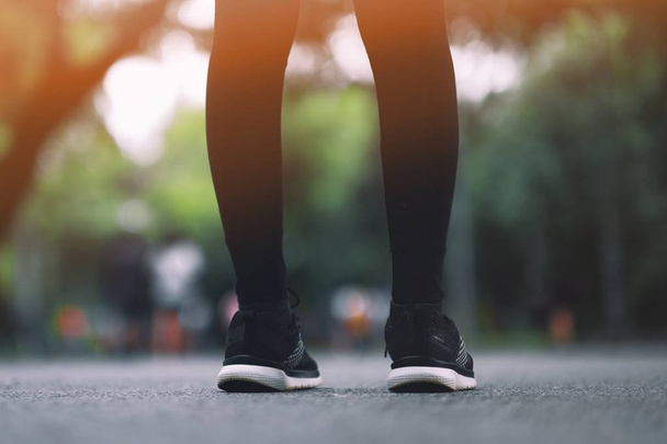 das Mädchen trägt schwarze Laufschuhe, um im Park zu laufen. - Foto, Bild