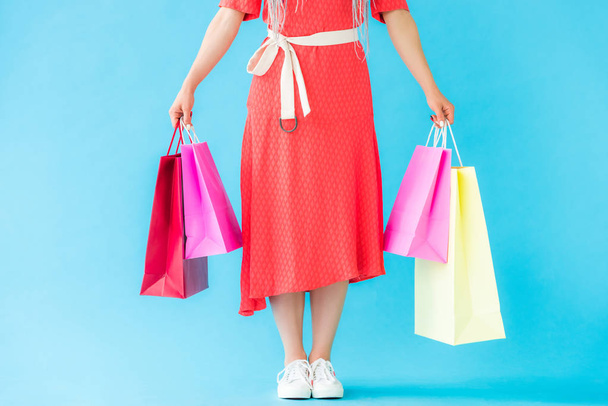 cropped view of fashionable girl with shopping bags on turquoise - Foto, imagen